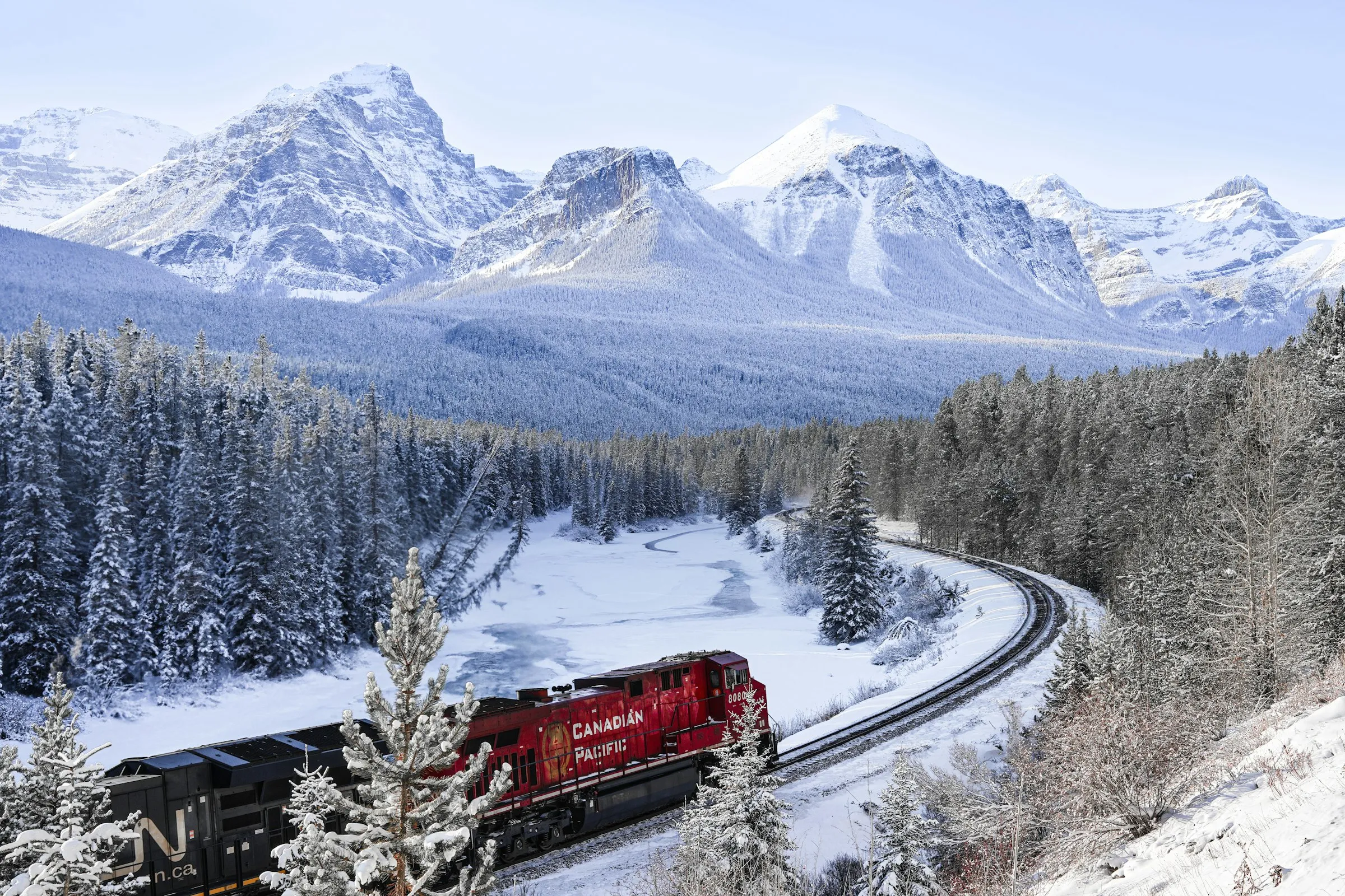 A Canadian Pacific freight train rounding Morant's Curve in the snow-covered Rocky Mountains near Lake Louise